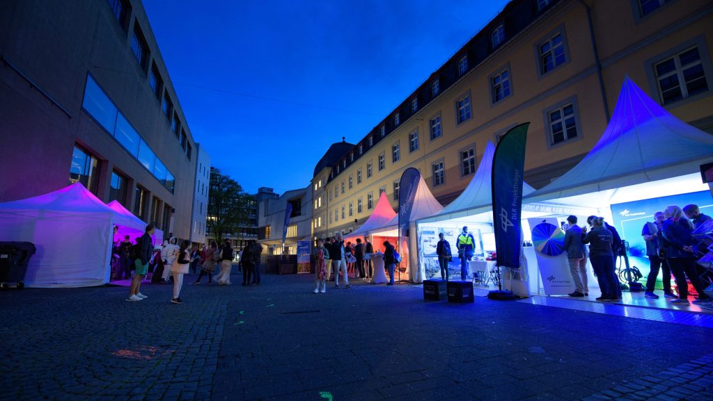 Zelte des Projektträgers Luftfahrtforschung, des DLR Projektträgers und der Raumfahrtagentur auf dem Bottlerplatz während der Bonner Wissenschaftsnacht 2024 bei Nacht
