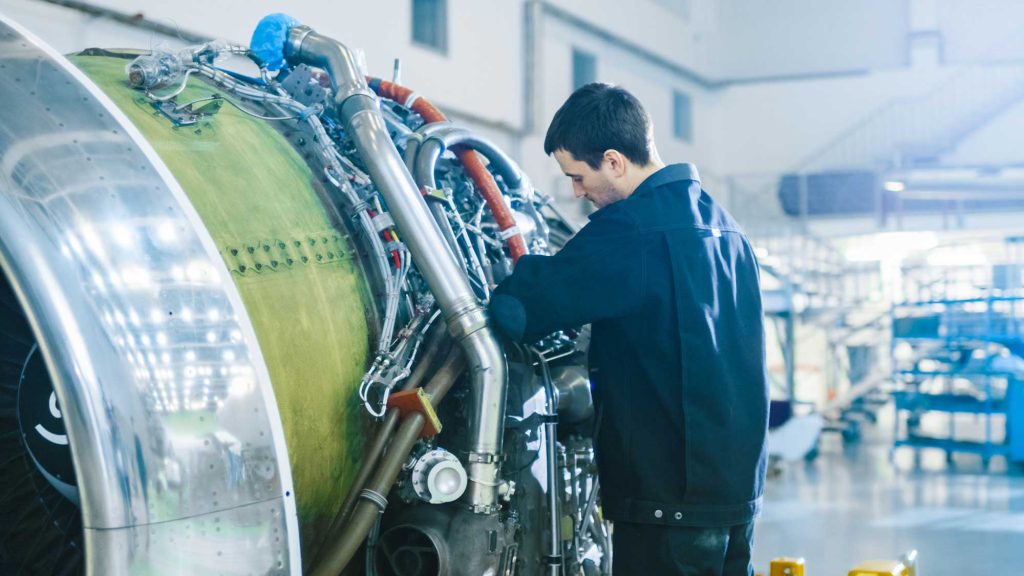 Mann arbeitet an einer Flugzeugturbine